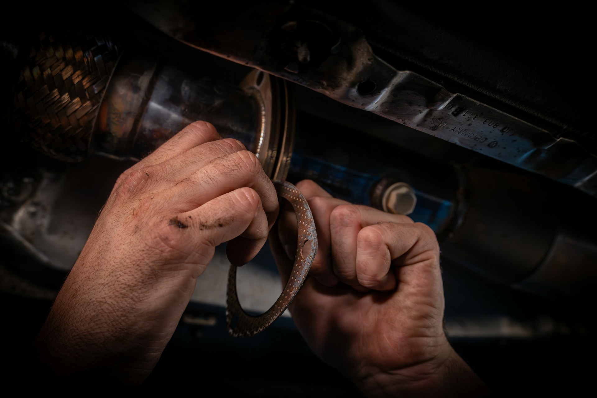 A man working on a cars engine with a wrench